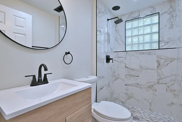 a bathroom with a sink mirror toilet and shower