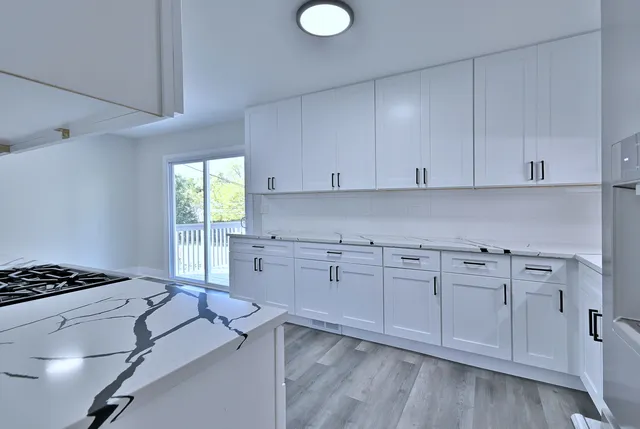 a kitchen with cabinets appliances and a window