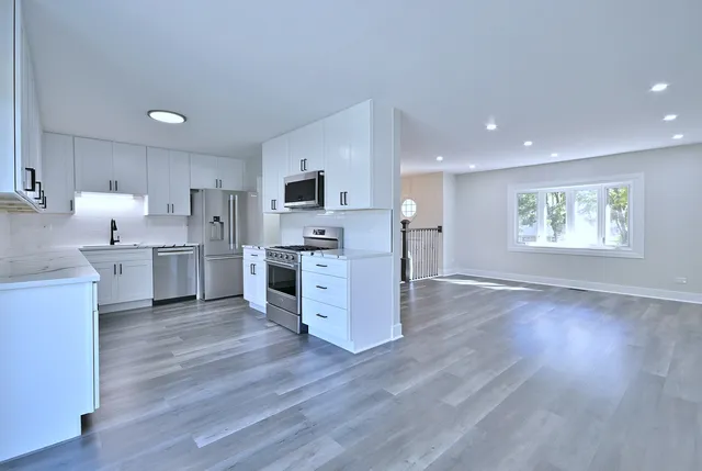 a view of kitchen with wooden floor and electronic appliances
