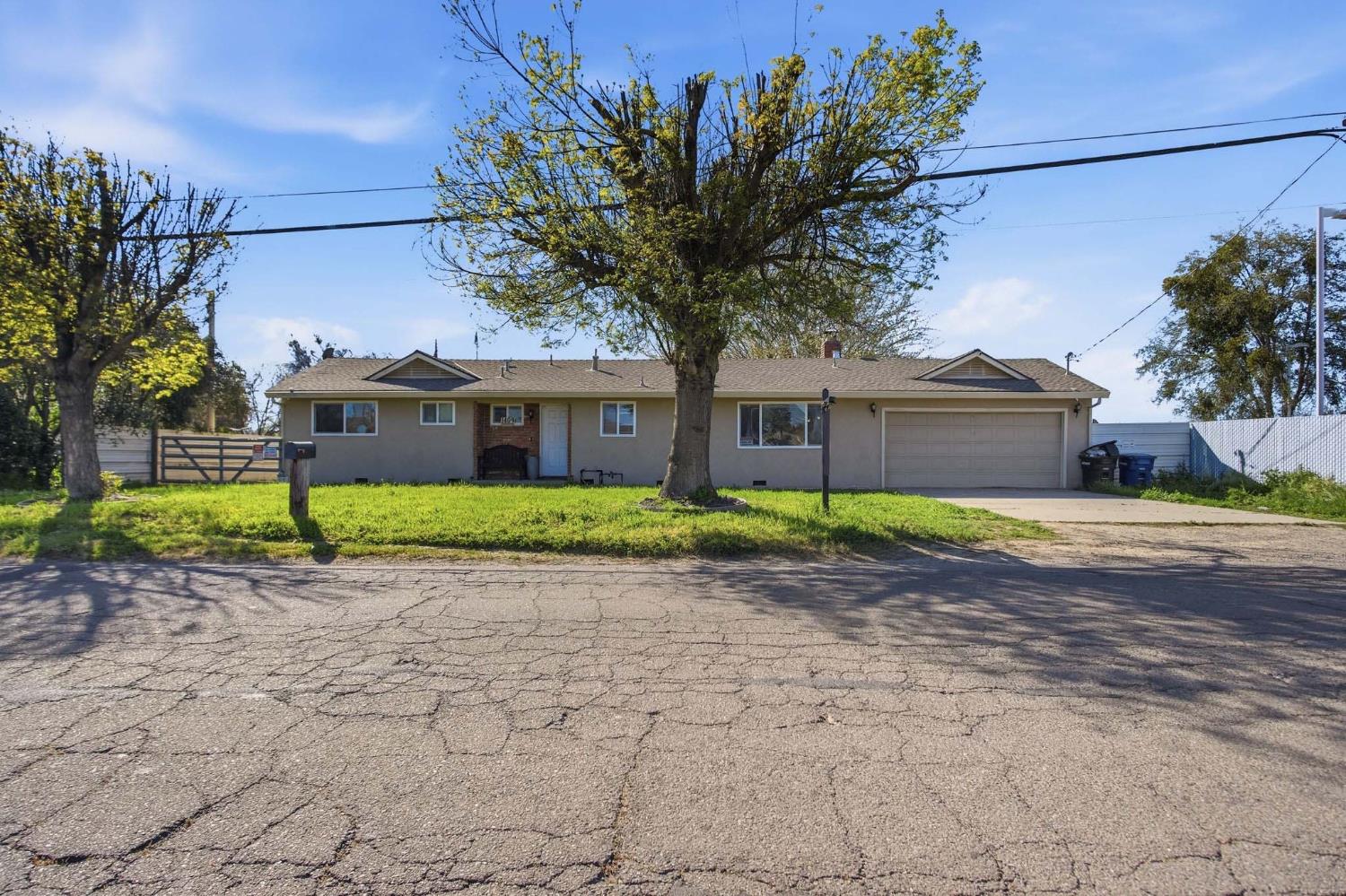 1409 Stonum Road Modesto, CA 95351 - Photo 4 of 40 a front view of a house with a garden and trees