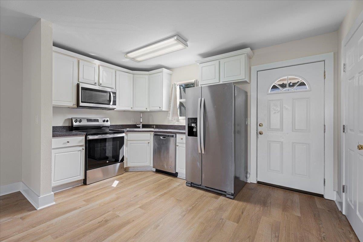 4420 Carter Road, Unit 33 St. Augustine, FL 32086 - Photo 7 of 20 a kitchen with granite countertop a refrigerator stove and wooden floor