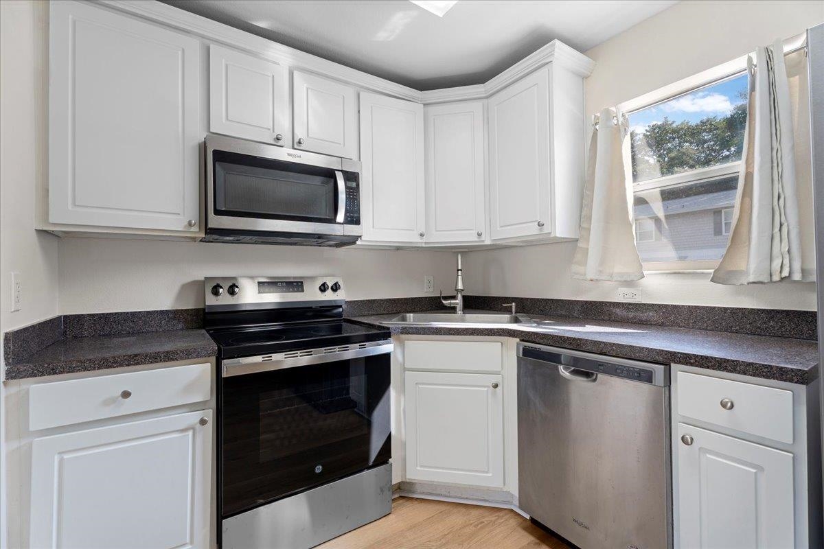4420 Carter Road, Unit 33 St. Augustine, FL 32086 - Photo 8 of 20 a kitchen with granite countertop white cabinets appliances and a window