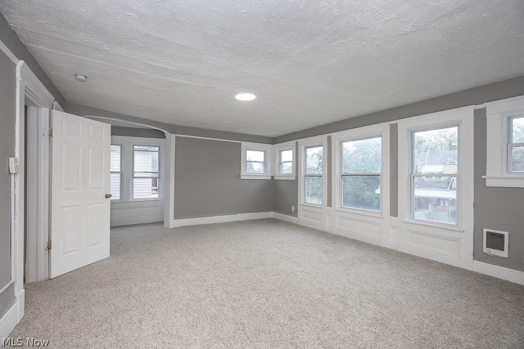 1892 Beersford Road Cleveland, OH 44112 - Photo 27 of 47 Carpeted spare room featuring a textured ceiling and plenty of natural light