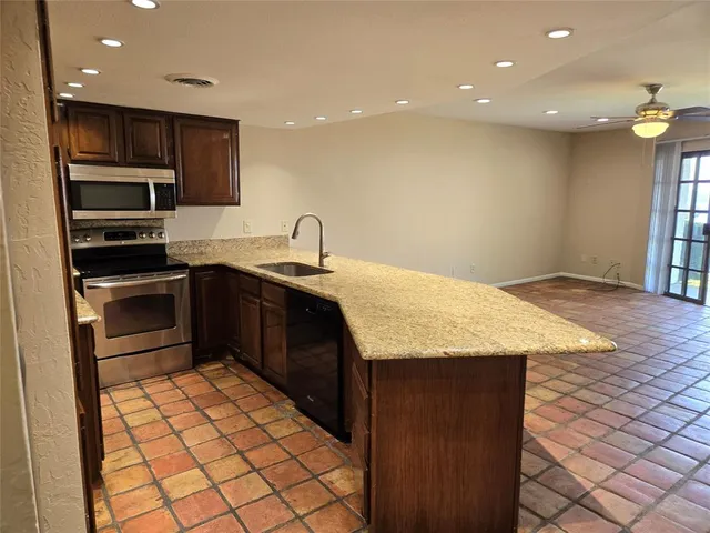 a kitchen with stainless steel appliances granite countertop a sink stove and refrigerator