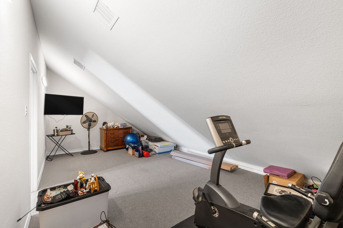 1116 Highknoll Lane Georgetown, TX 78628 - Photo 35 of 36 a room with gym equipment and a flat screen tv