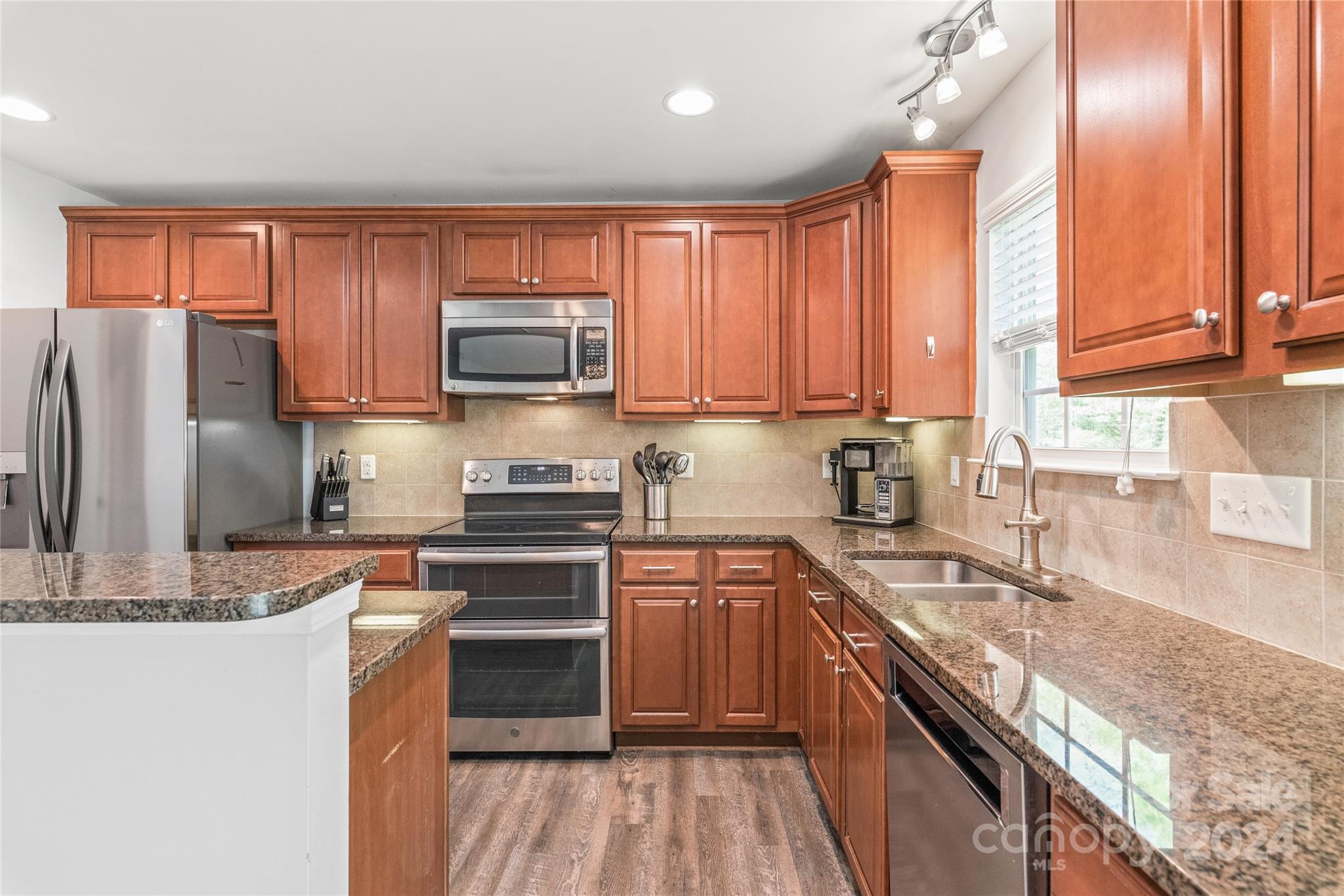 11616 Mud Drive Midland, NC 28107 - Photo 8 of 29 a kitchen with stainless steel appliances granite countertop a stove a sink and a refrigerator with wooden cabinets