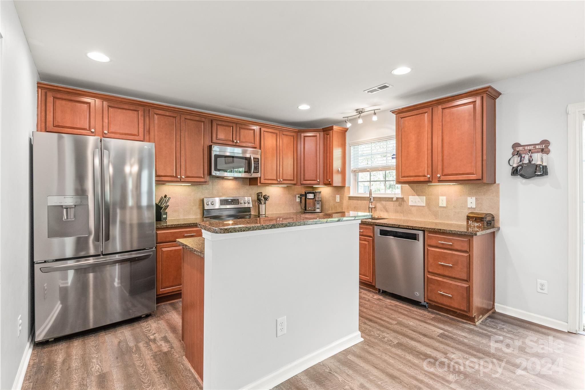 11616 Mud Drive Midland, NC 28107 - Photo 9 of 29 a kitchen with granite countertop stainless steel appliances a refrigerator sink and microwave