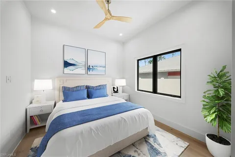 a bedroom with a large bed and a potted plant