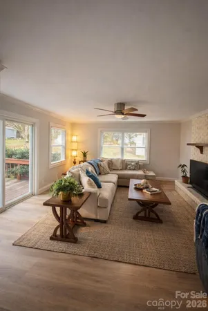 a living room with furniture large window and a table