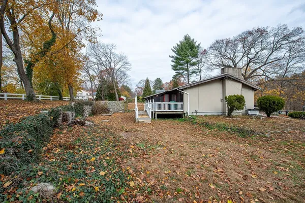 a view of a house with backyard and trees