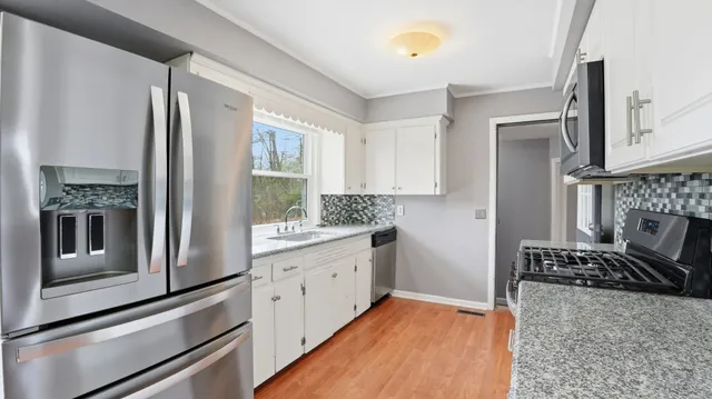 a kitchen with stainless steel appliances granite countertop a refrigerator and a stove