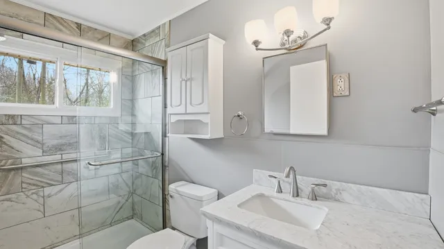 a bathroom with a sink toilet and shower