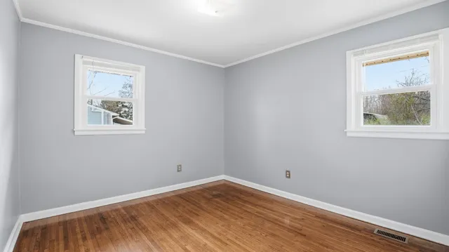 a view of room with window and wooden floor