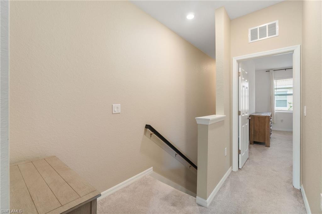 2767 Blossom Way Naples, FL 34120 - Photo 11 of 38 a view of a hallway with a cabinet and a mirror
