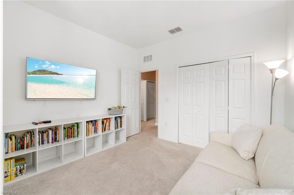 2767 Blossom Way Naples, FL 34120 - Photo 12 of 38 a living room with furniture and a book shelf