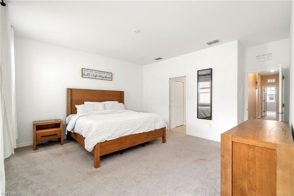 2767 Blossom Way Naples, FL 34120 - Photo 14 of 38 a bed sitting in a spacious bedroom next to a window