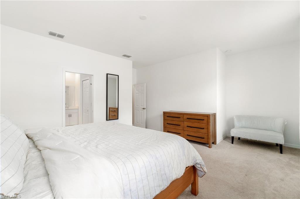 2767 Blossom Way Naples, FL 34120 - Photo 15 of 38 a bedroom with a bed and a couch