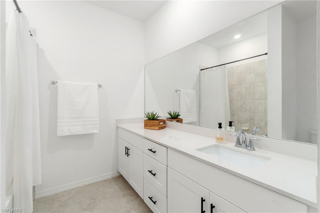 2767 Blossom Way Naples, FL 34120 - Photo 17 of 38 a bathroom with a double vanity sink and mirror