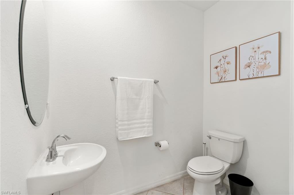 2767 Blossom Way Naples, FL 34120 - Photo 18 of 38 a bathroom with a toilet sink and mirror