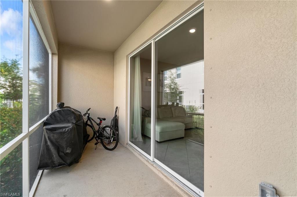 2767 Blossom Way Naples, FL 34120 - Photo 27 of 38 a living room with furniture and a floor to ceiling window