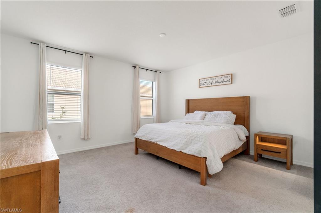 2767 Blossom Way Naples, FL 34120 - Photo 6 of 38 a bed sitting in a spacious bedroom next to a window