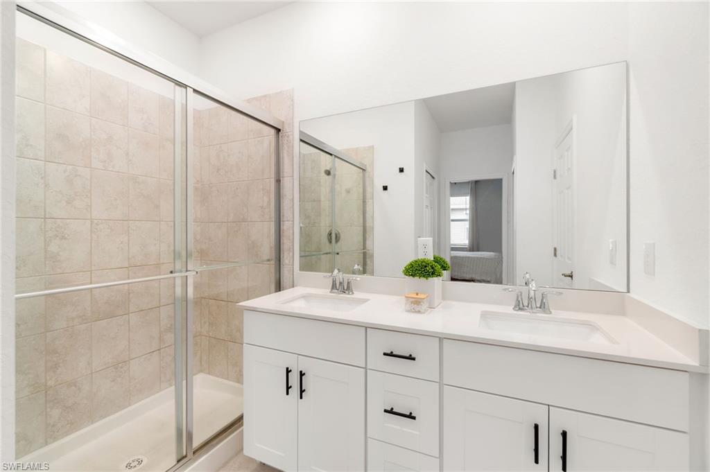 2767 Blossom Way Naples, FL 34120 - Photo 7 of 38 a bathroom with a shower sink and mirror