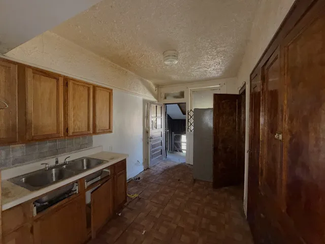 a kitchen with granite countertop a refrigerator and a sink