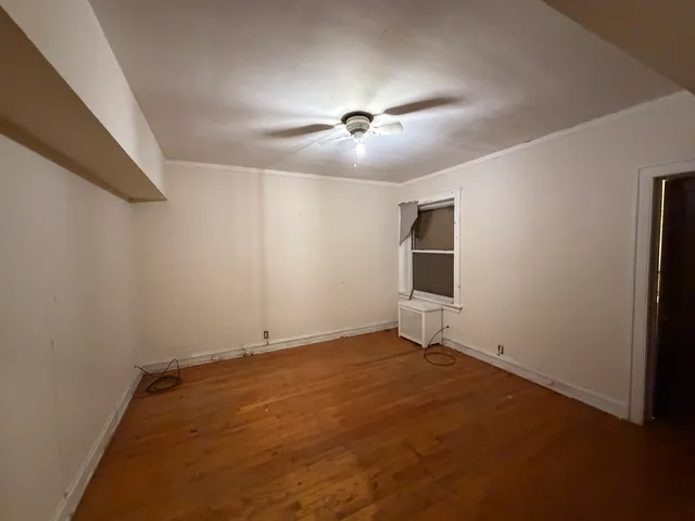 en empty room with ceiling fan and window