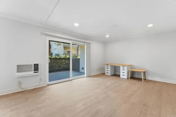 an empty room with furniture and a floor to ceiling window