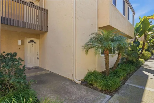 a view of a house with a yard and potted plants