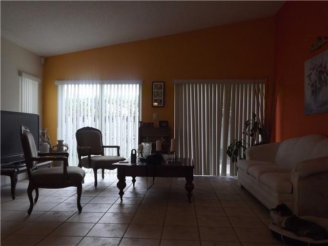 8410 Southwest 157th Court Miami, FL 33193 - Photo 4 of 15 a living room with couches a coffee table and a piano next to a window
