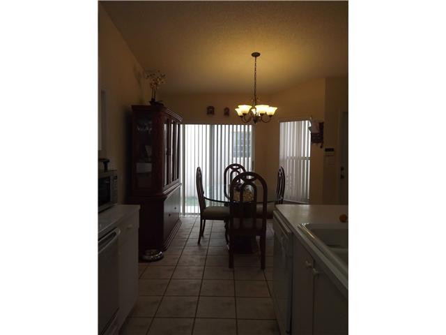 8410 Southwest 157th Court Miami, FL 33193 - Photo 6 of 15 a kitchen with a refrigerator and chandelier