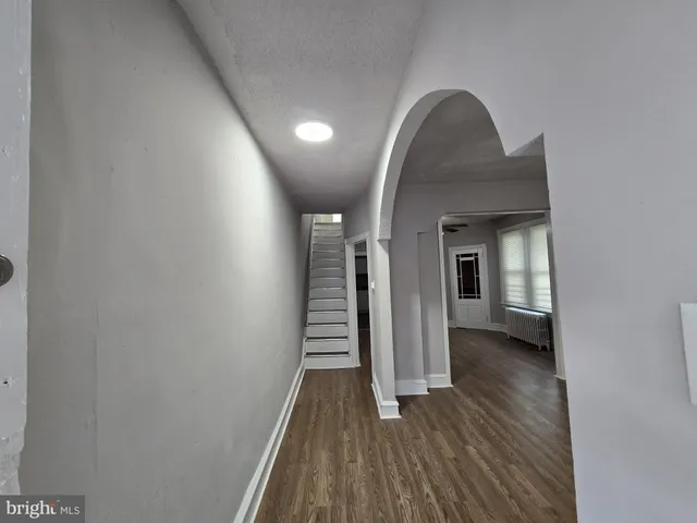 a view of a livingroom with wooden floor and stairs