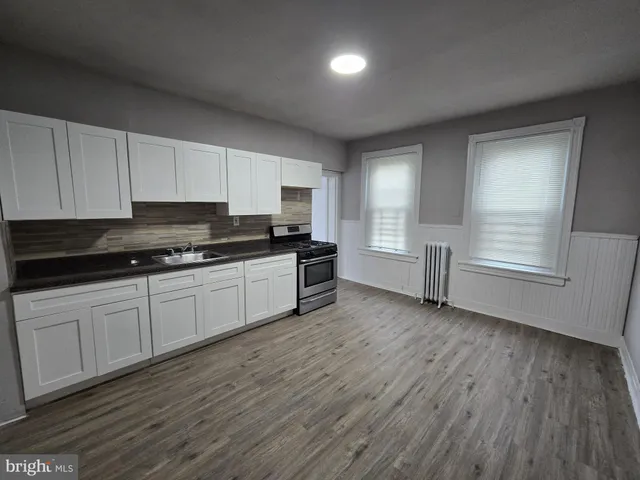 a kitchen with wooden floors and white appliances
