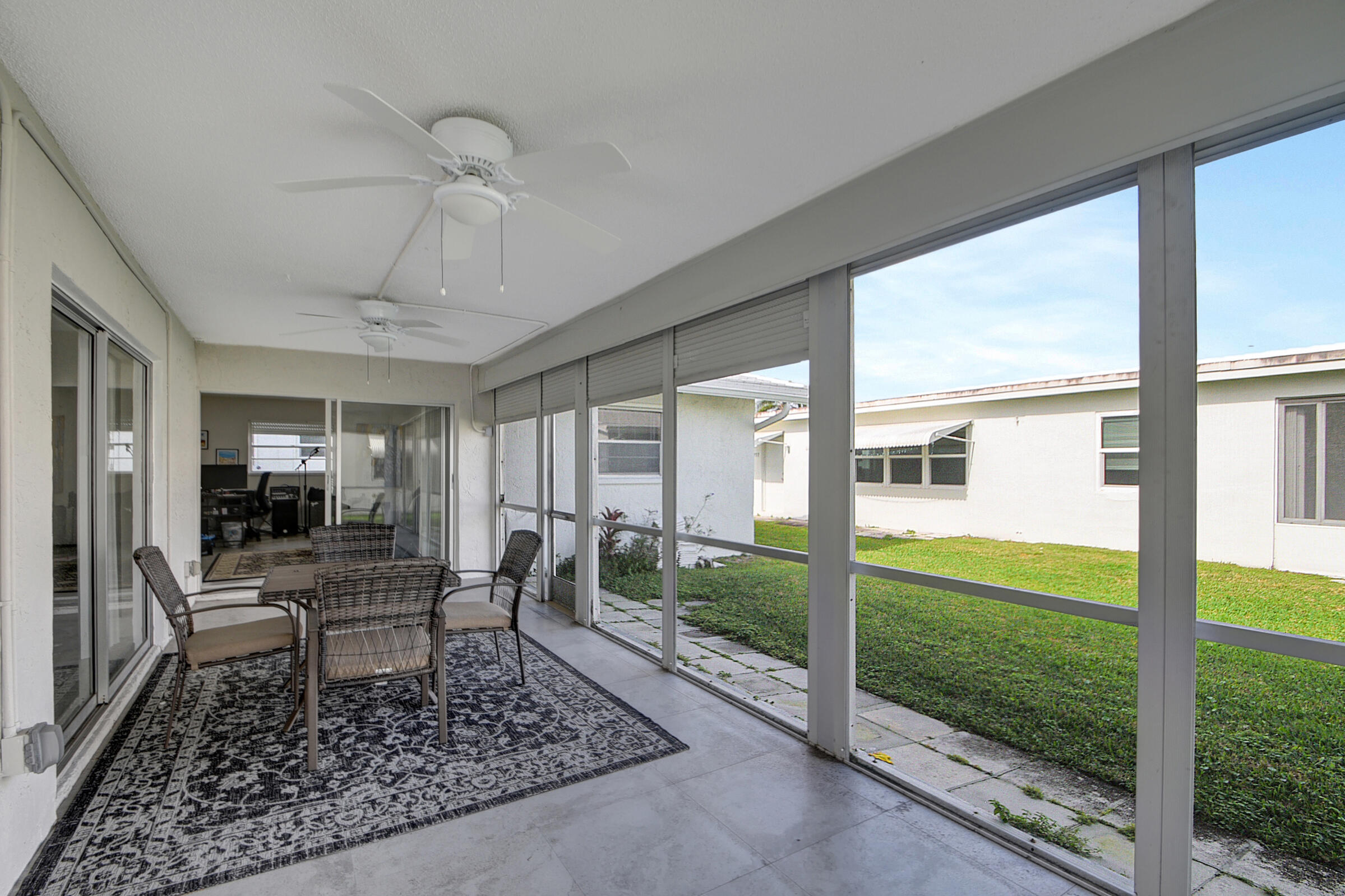 716 Southwest 18th Street Boynton Beach, FL 33426 - Photo 50 of 65 a living room with patio furniture and a floor to ceiling window