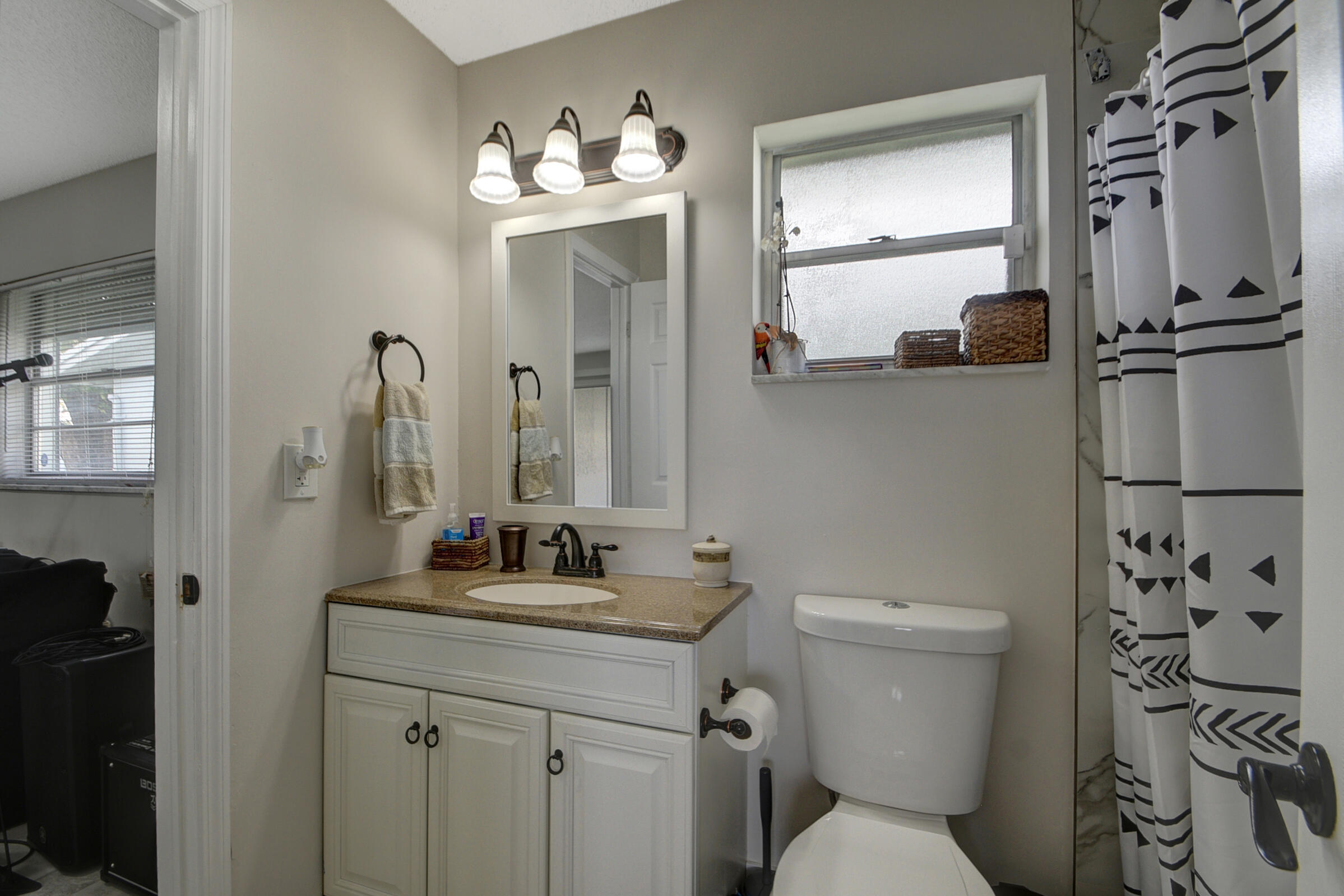 716 Southwest 18th Street Boynton Beach, FL 33426 - Photo 53 of 65 a bathroom with a toilet a sink and mirror