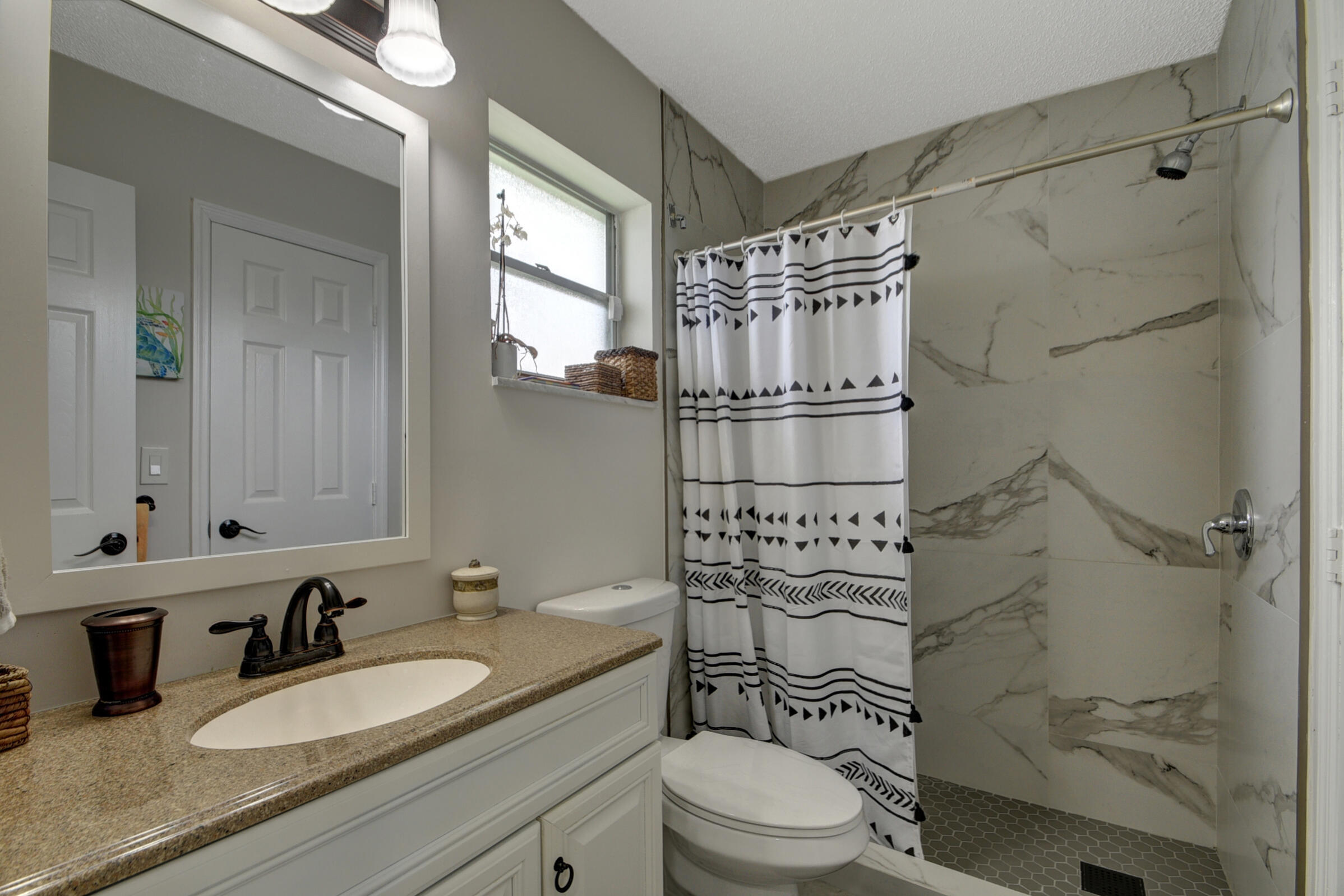 716 Southwest 18th Street Boynton Beach, FL 33426 - Photo 54 of 65 a bathroom with a sink toilet a mirror and shower