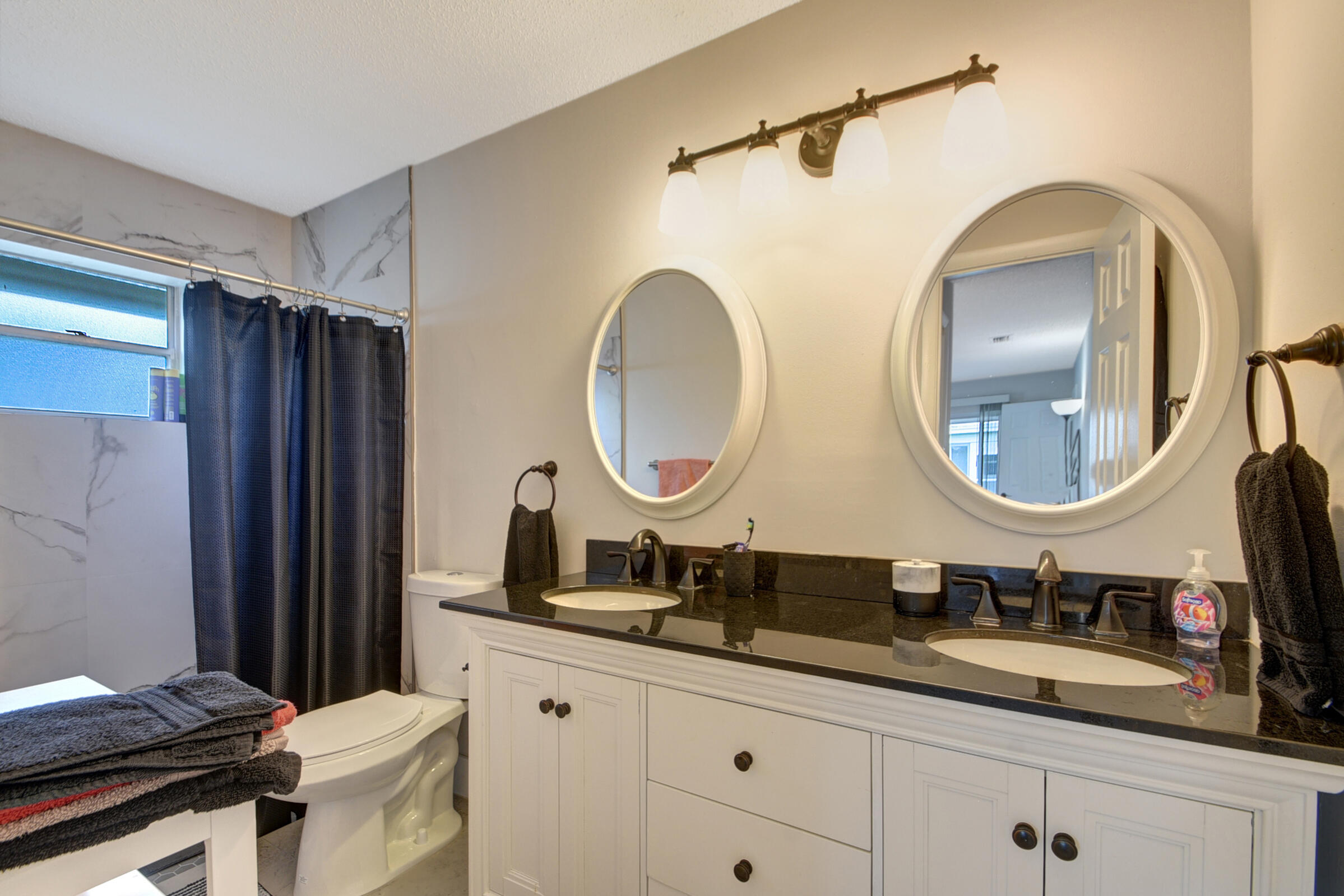 716 Southwest 18th Street Boynton Beach, FL 33426 - Photo 63 of 65 a bathroom with a double vanity sink and a mirror