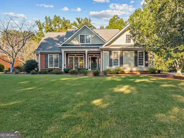 a front view of a house with a yard and trees