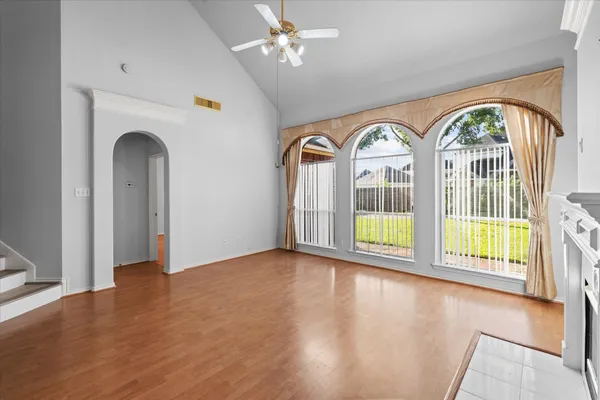 a view of an empty room with a window and wooden floor