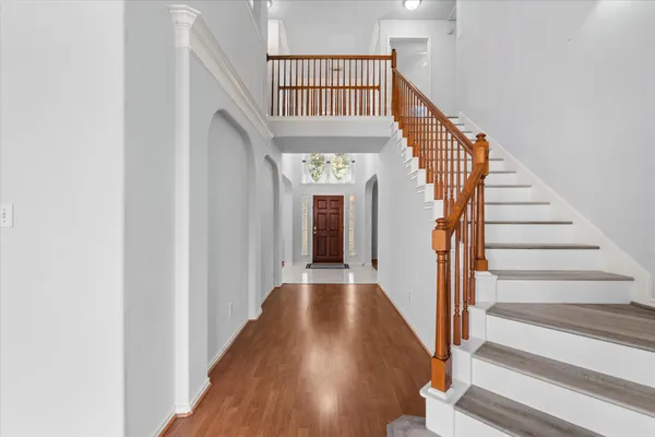 a view of staircase with lots of frames on wall and a window
