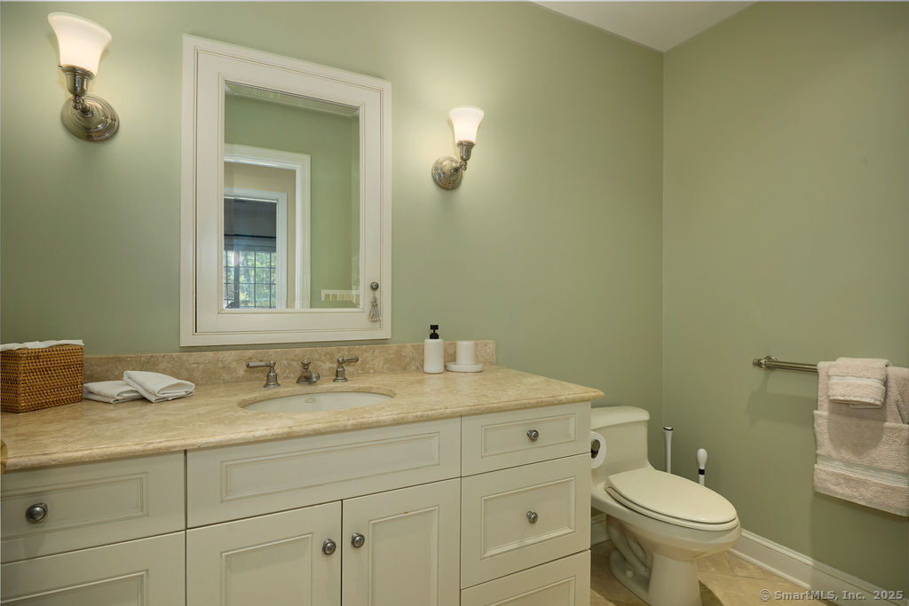 81 Norfield Road Weston, CT 06883 - Photo 25 of 40 a bathroom with a granite countertop toilet sink and mirror