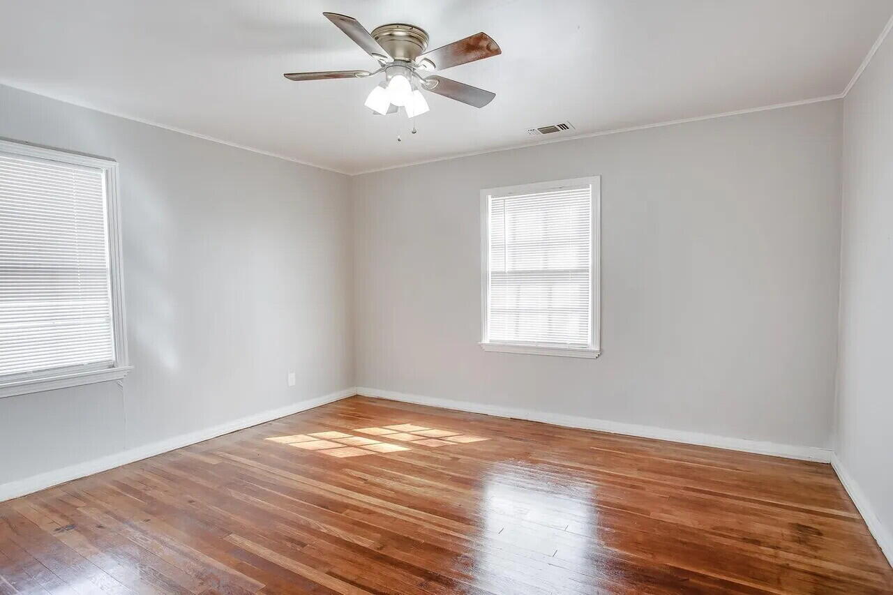 2706 36th Street Lubbock, TX 79413 - Photo 9 of 15 a view of empty room with wooden floor and fan