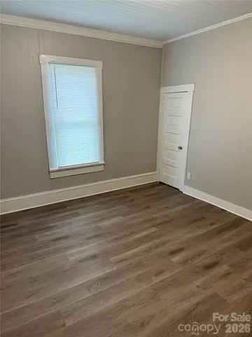 a view of a room that has wooden floor and brick walls