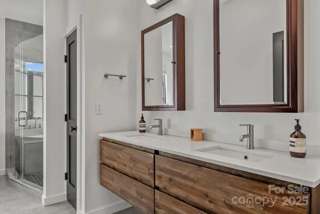 a bathroom with a double vanity sink a mirror and a bathtub