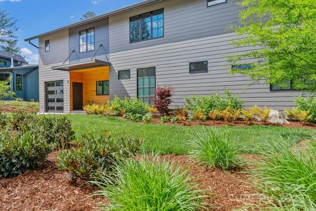 a front view of a house with garden and plants