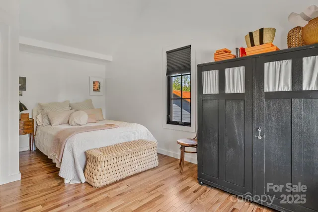 a bedroom with a bed a bookshelf and a flat screen tv