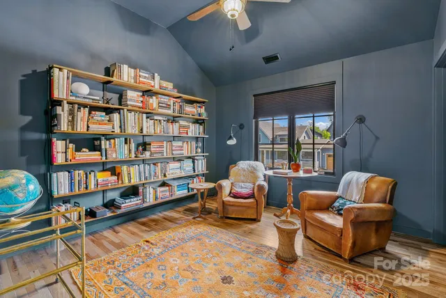 a living room with patio furniture and floor to ceiling windows