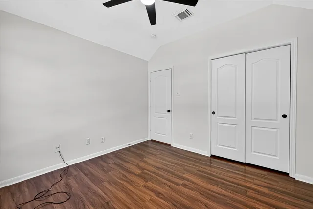 a view of an empty room with wooden floor