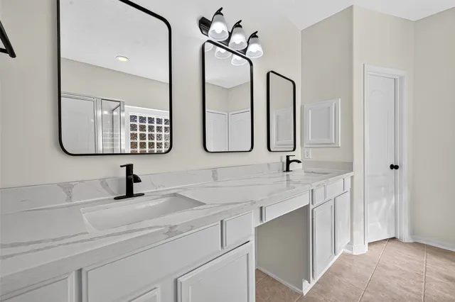 a bathroom with a double vanity sink and a mirror